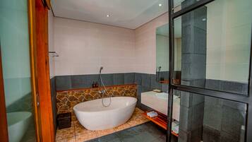 A modern bathroom with a freestanding bathtub, a glass shower enclosure, and a vanity with a mirror.