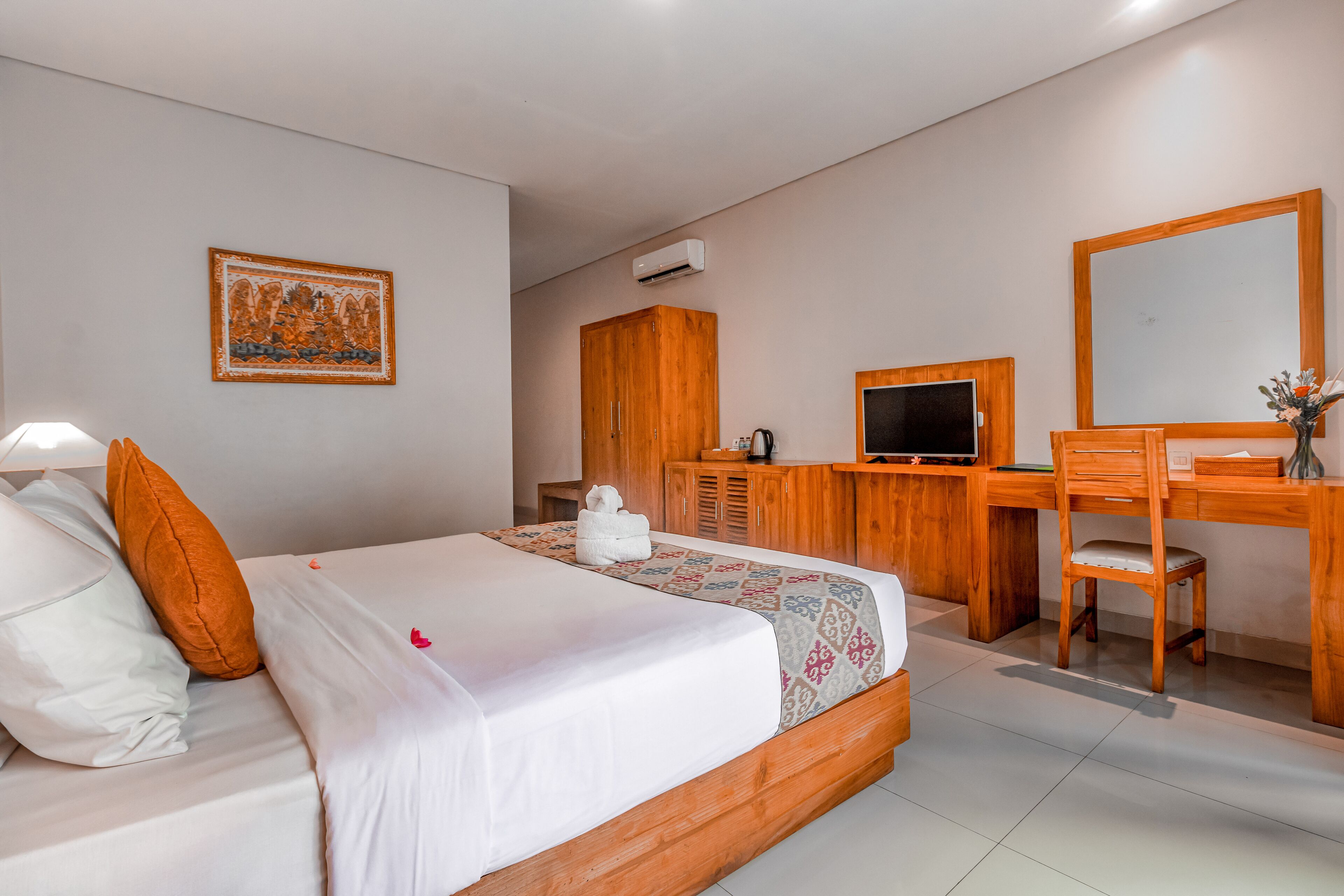 Habitación de hotel con cama, escritorio, silla, televisión y armario.