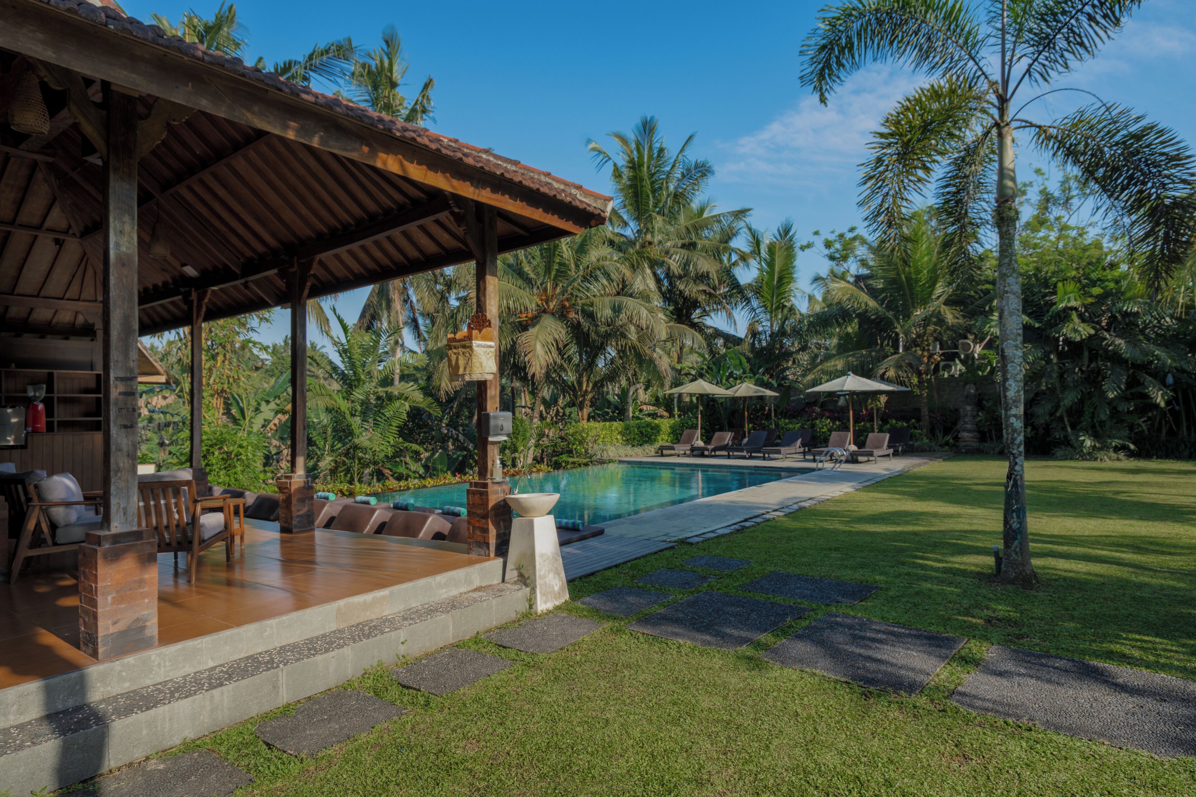 A poolside area with a covered seating area, lounge chairs, and a clear view of the pool.