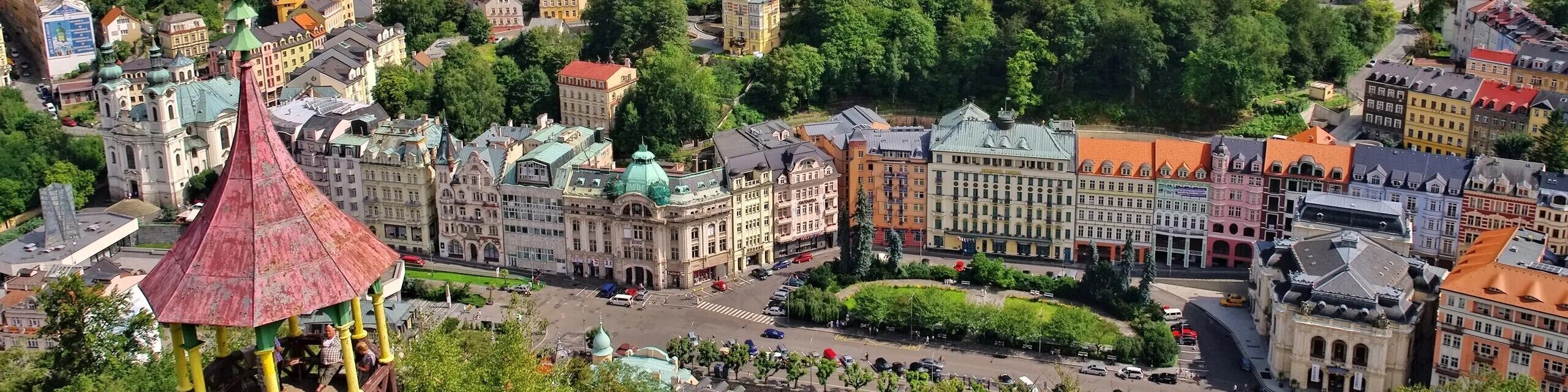 Vista aérea de un paisaje urbano con edificios históricos, una iglesia destacada y una plaza central.