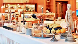A buffet with various food items and a statue. - Olympia Wellness Hotel (Karlovy Vary)