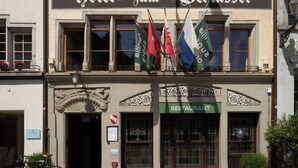 Un hôtel avec une enseigne indiquant « Hotel zum Schüssel » et, en dessous, une enseigne pour le restaurant.