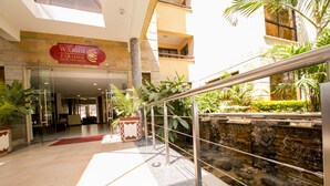 A hotel entrance with a stone facade, indoor plants, and a water feature. - Waridi Paradise Hotel & Suites (Nairobi)