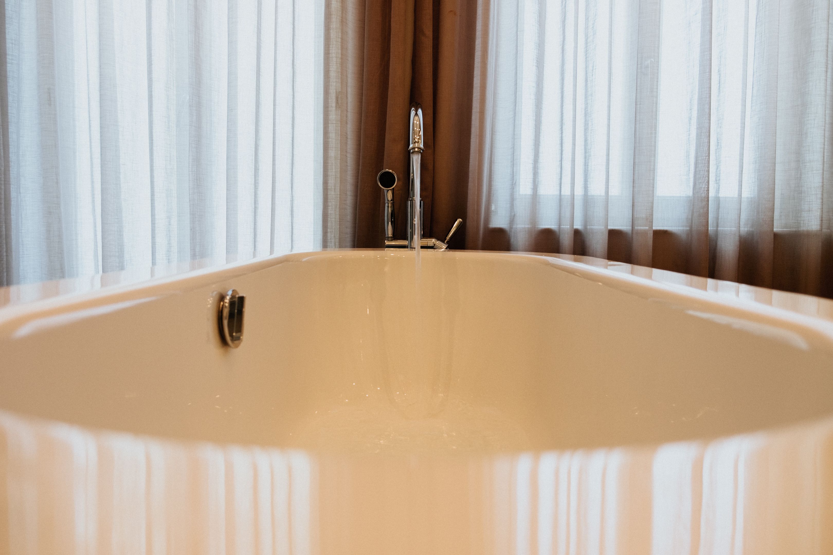 Una bañera con grifo y ducha de mano.
