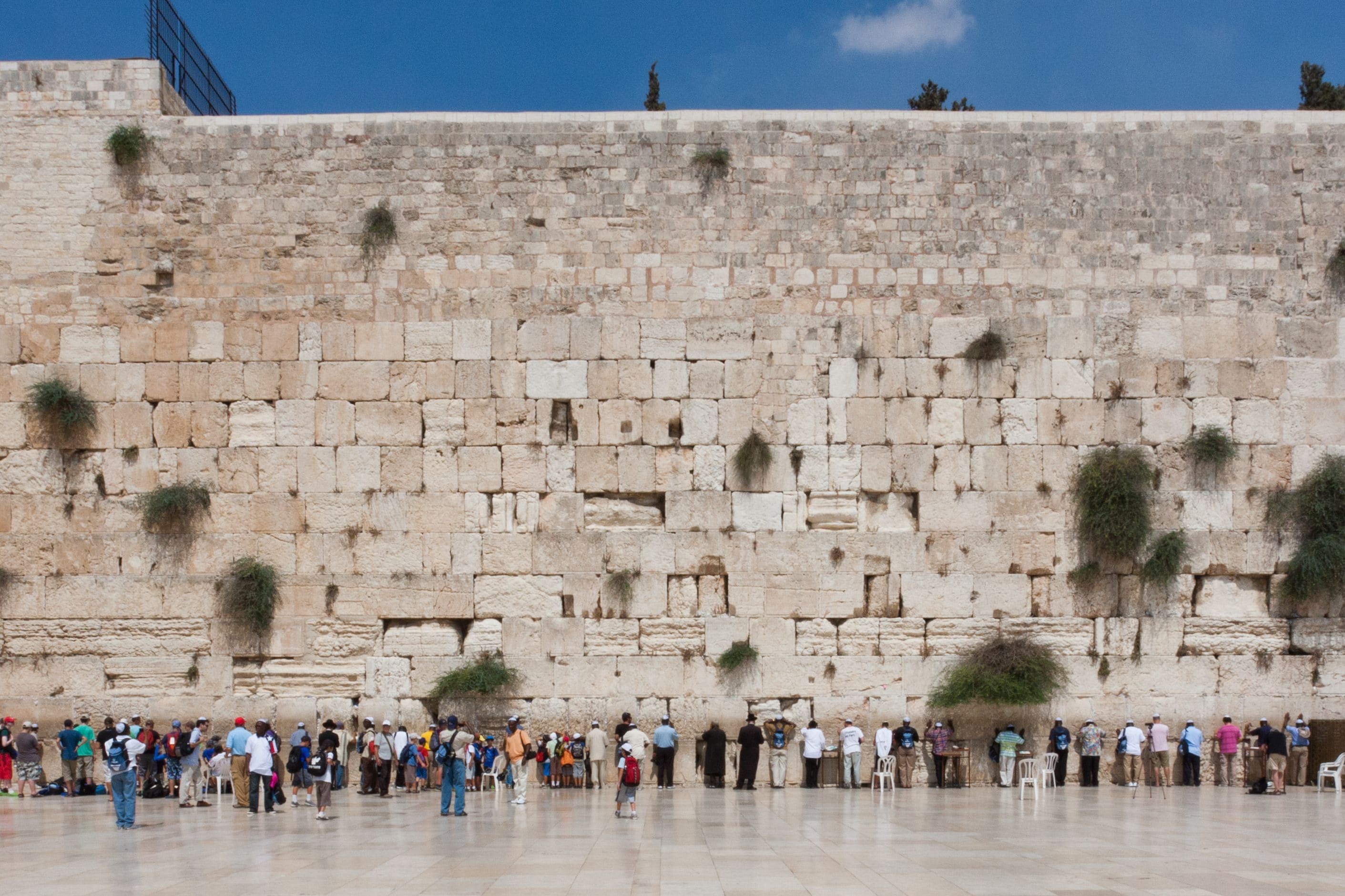 Un muro de piedra con personas paradas delante.
