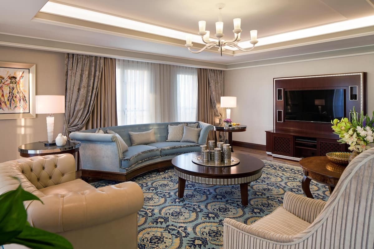 A living room with a sofa, armchair, coffee table, and a TV.