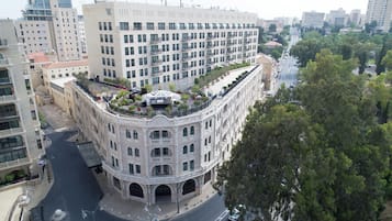 A multi-story building with a central courtyard, balconies, and a street view.