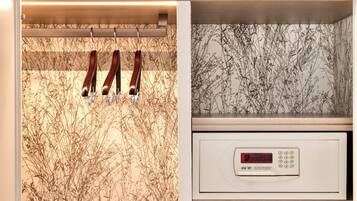 Uma cozinha com forno digital, um varal de utensílios e uma parede com padrão floral.
