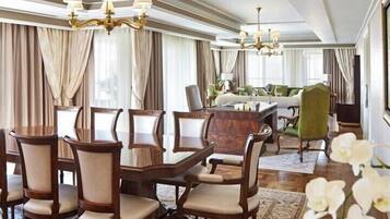 A formal dining room with a wooden table and chairs, a sofa, and a chandelier.