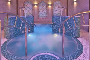 Una piscina techada, sillones reclinables de piscina