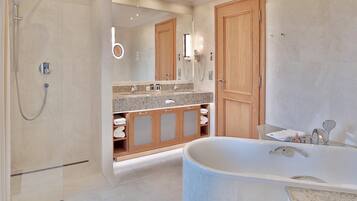 A modern bathroom with a walk-in shower, a freestanding bathtub, and a vanity with a granite countertop.