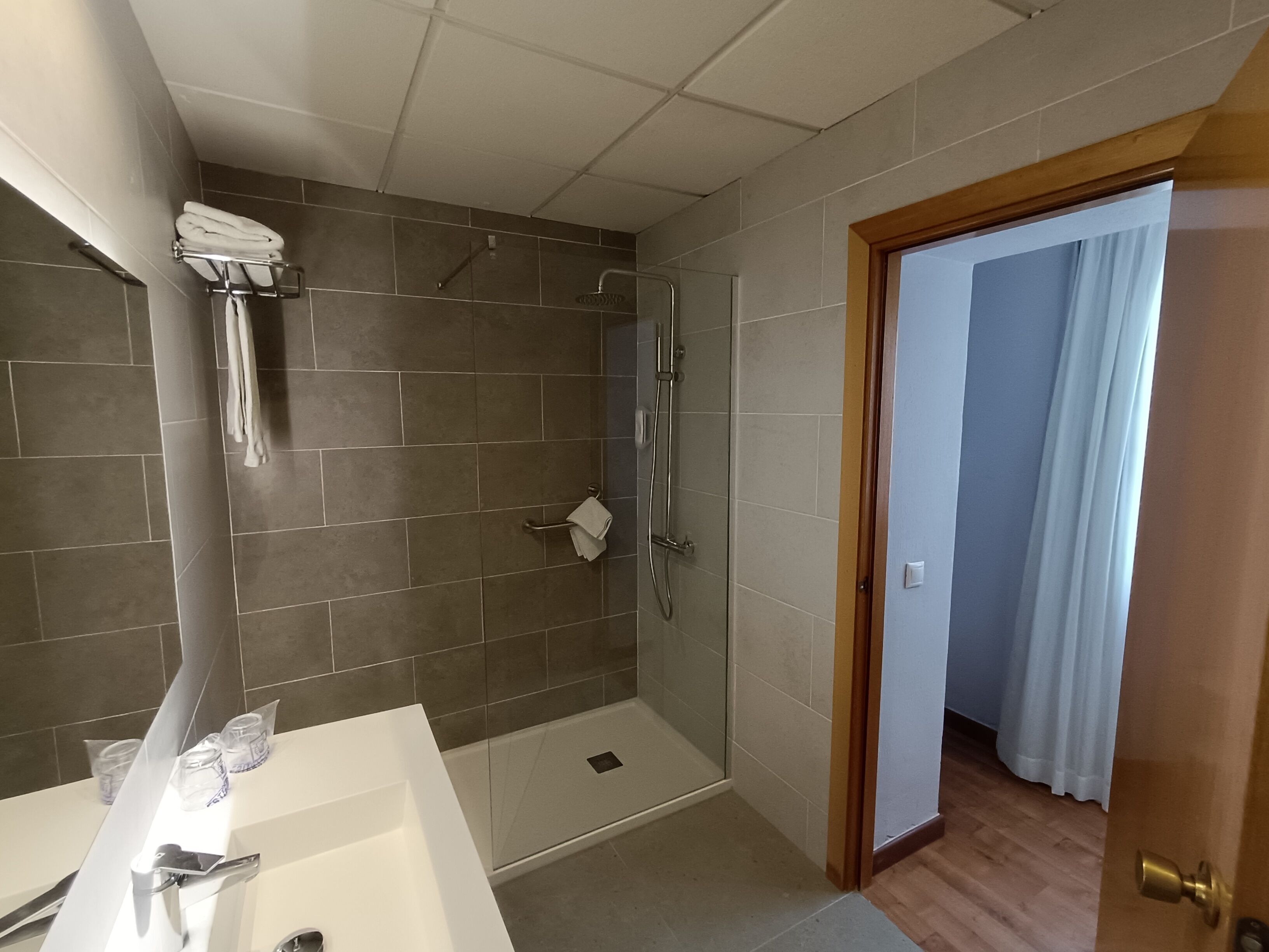 A bathroom with a shower, a sink, and a toilet.