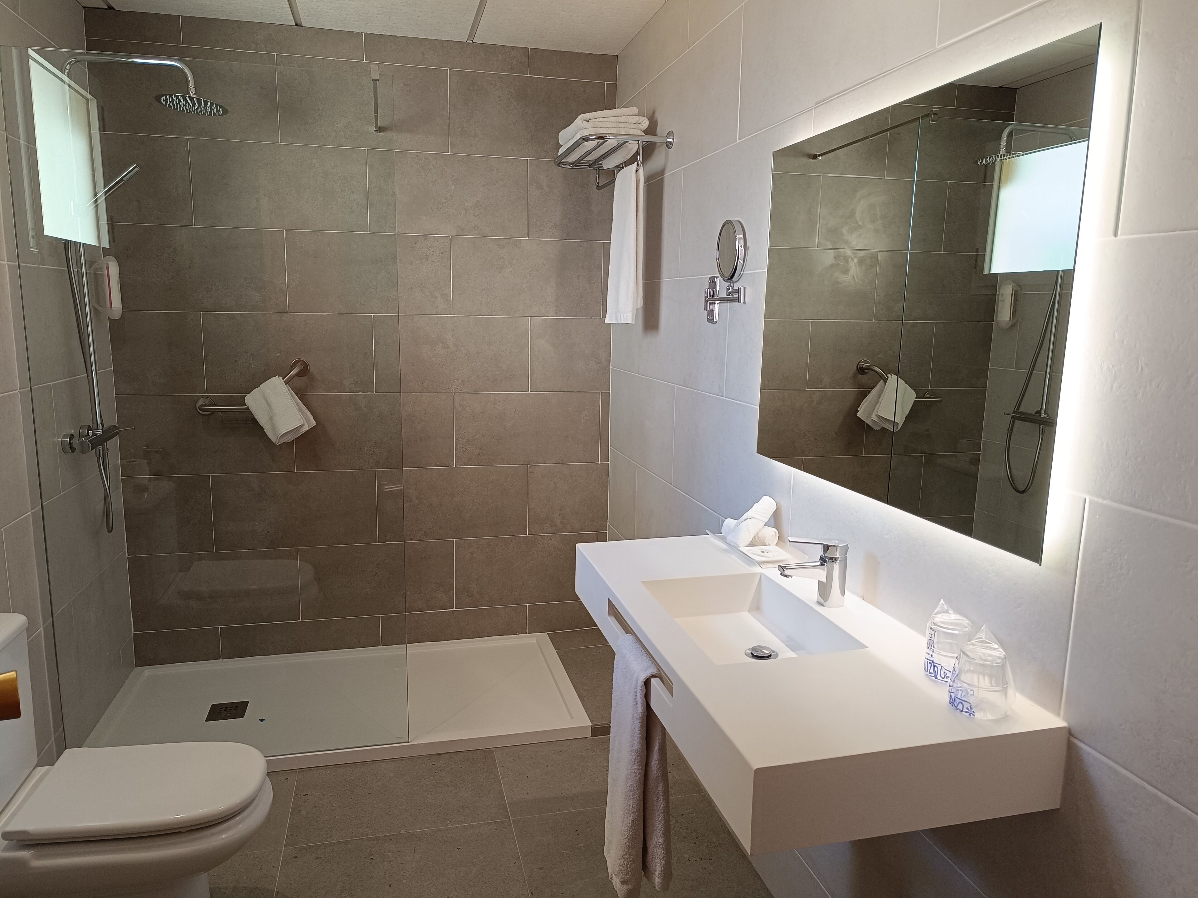 Un baño moderno con ducha, inodoro y tocador.