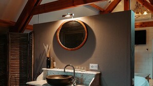A bathroom with a wooden vanity, a round mirror, and a vessel sink. - Hotel Ter Zuidhoek (Roeselare)