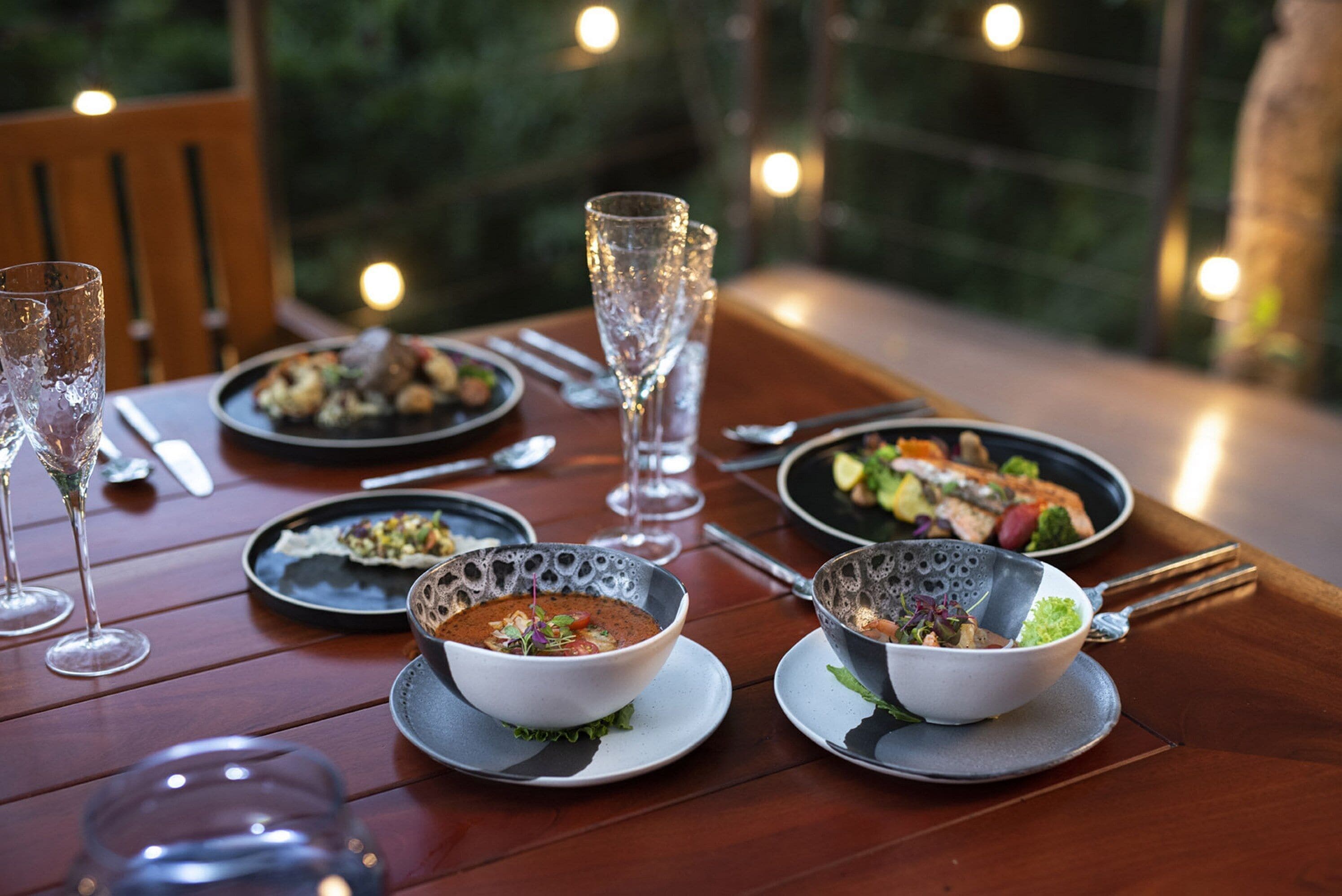 A dining table with various dishes, glasses, and cutlery.