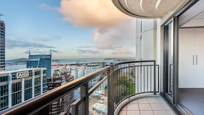 Ein Balkon mit Blick auf eine Stadtansicht, darunter ein Gebäude mit der Aufschrift 'AIG' und 'Lumley'.
