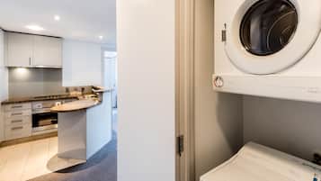 A modern kitchen with a built-in oven, a countertop, and a washing machine.