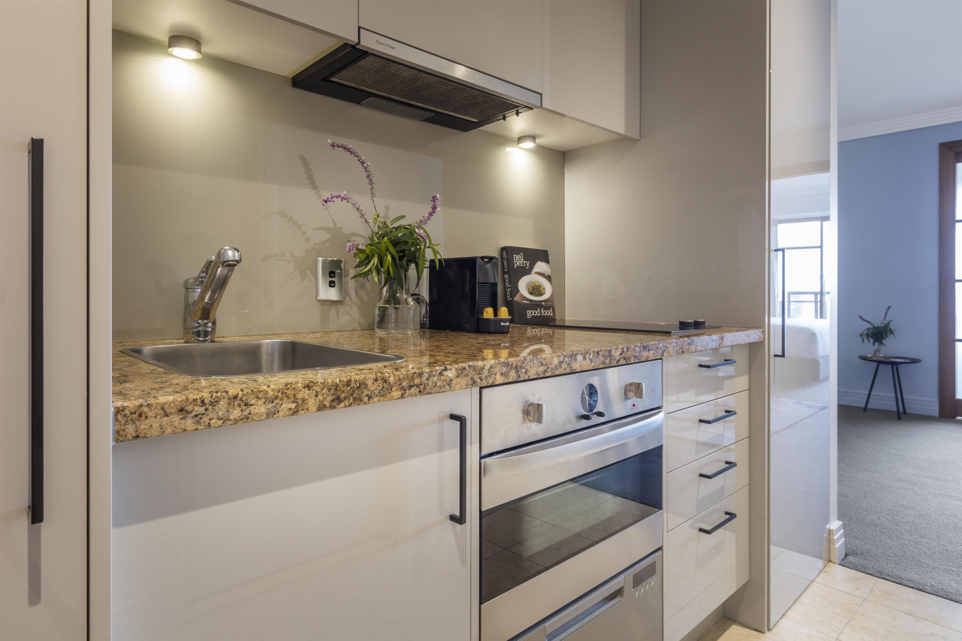 A modern kitchen with a granite countertop, stainless steel appliances, and a built-in oven.