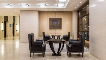 Sala de conferência com uma mesa redonda, seis cadeiras e um quadro abstrato grande na parede.