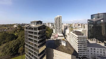A high-rise building with a modern architectural design, surrounded by other buildings and greenery.