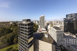 A high-rise building with a modern architectural design, surrounded by other buildings and greenery. - Avani Auckland Metropolis Residences (Auckland)