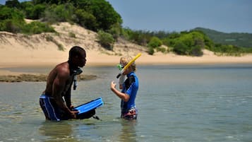 Dos personas en aguas poco profundas, una sosteniendo una cámara y la otra, una correa para cámara.