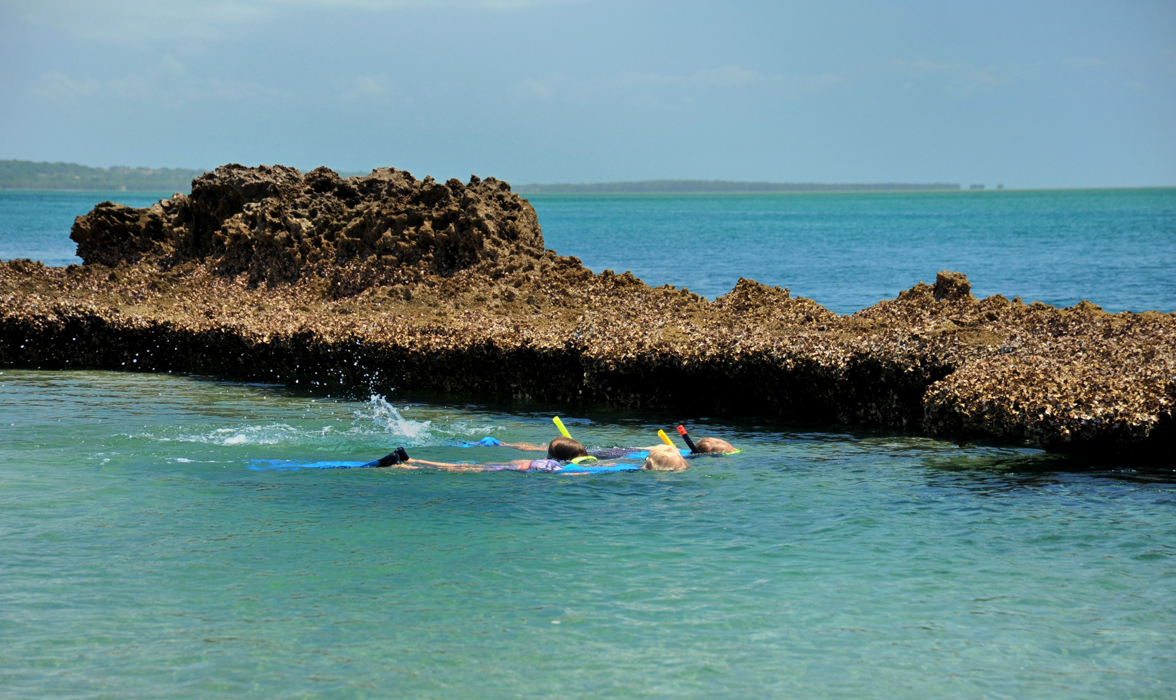 Una costa rocosa con aguas azul cristalino.