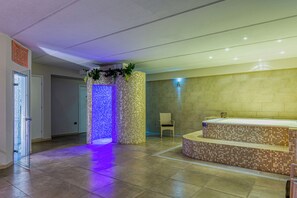 Un baño moderno con pared de mosaicos, puerta de vidrio y zona de estar.