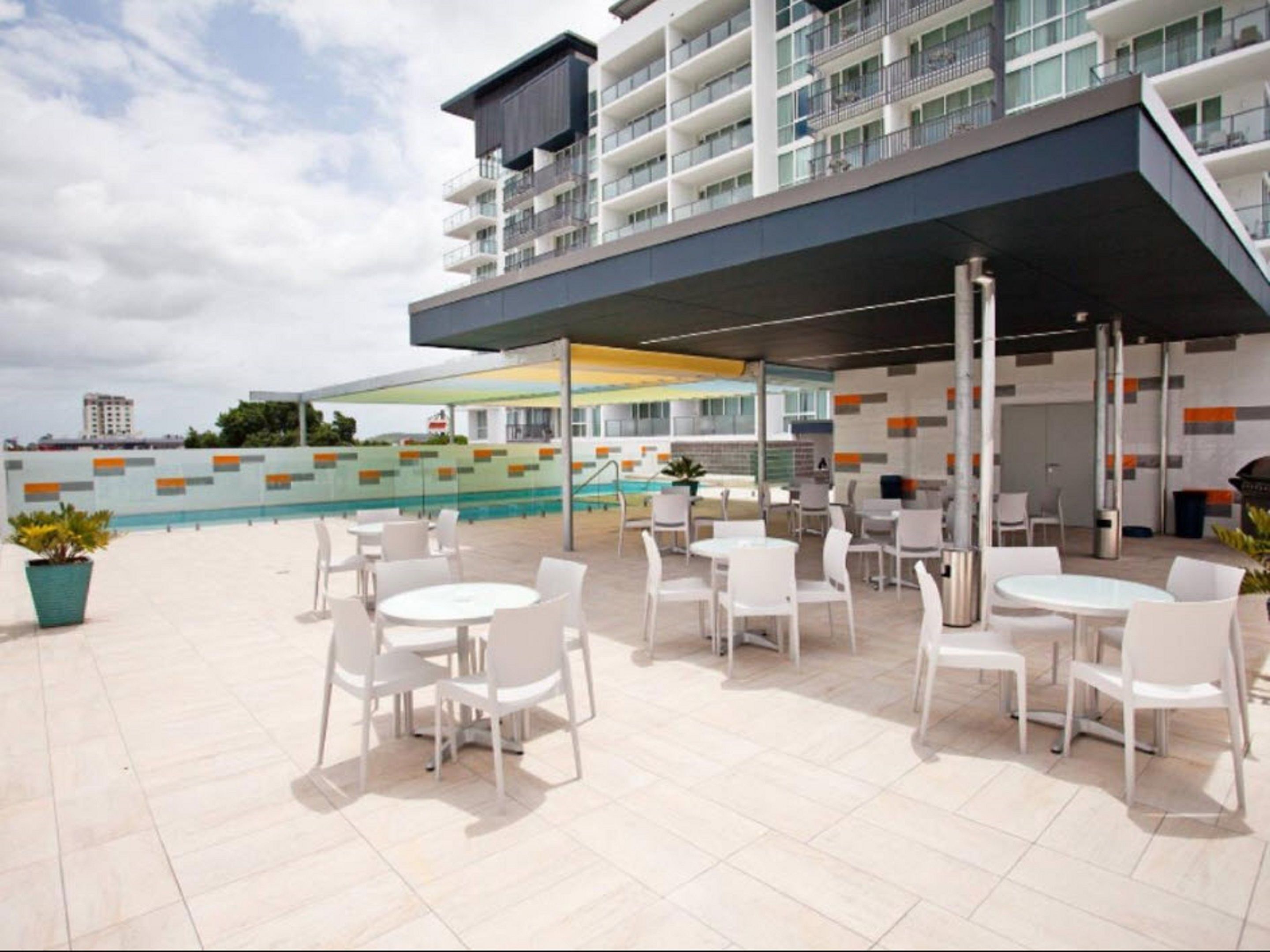 Une terrasse sur le toit avec des sièges extérieurs et une piscine.