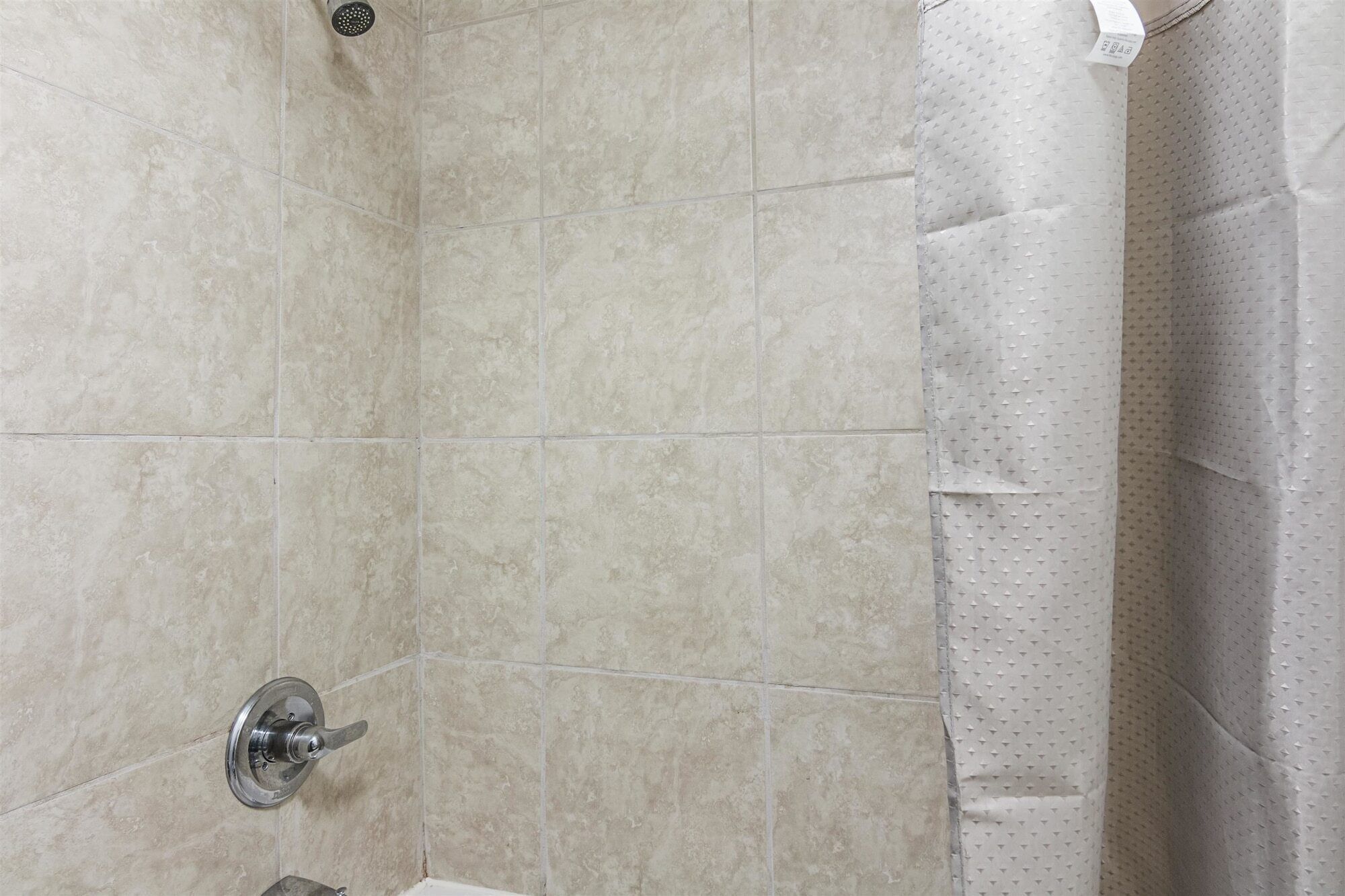A shower area with tiled walls and a showerhead.