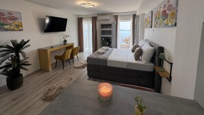 A modern bedroom with a bed, desk, TV, and a balcony with a view. - Arba Seaview Residences (Zupa dubrovacka)