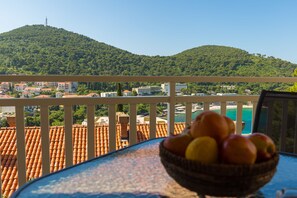 A balcony with a view of a hillside and a body of water. - Apartments Mandy (Dubrovnik)