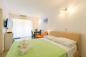 Una habitación de hotel con cama, escritorio, silla y televisor.