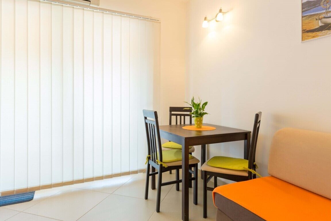 A dining area with a table, chairs, and a sofa.