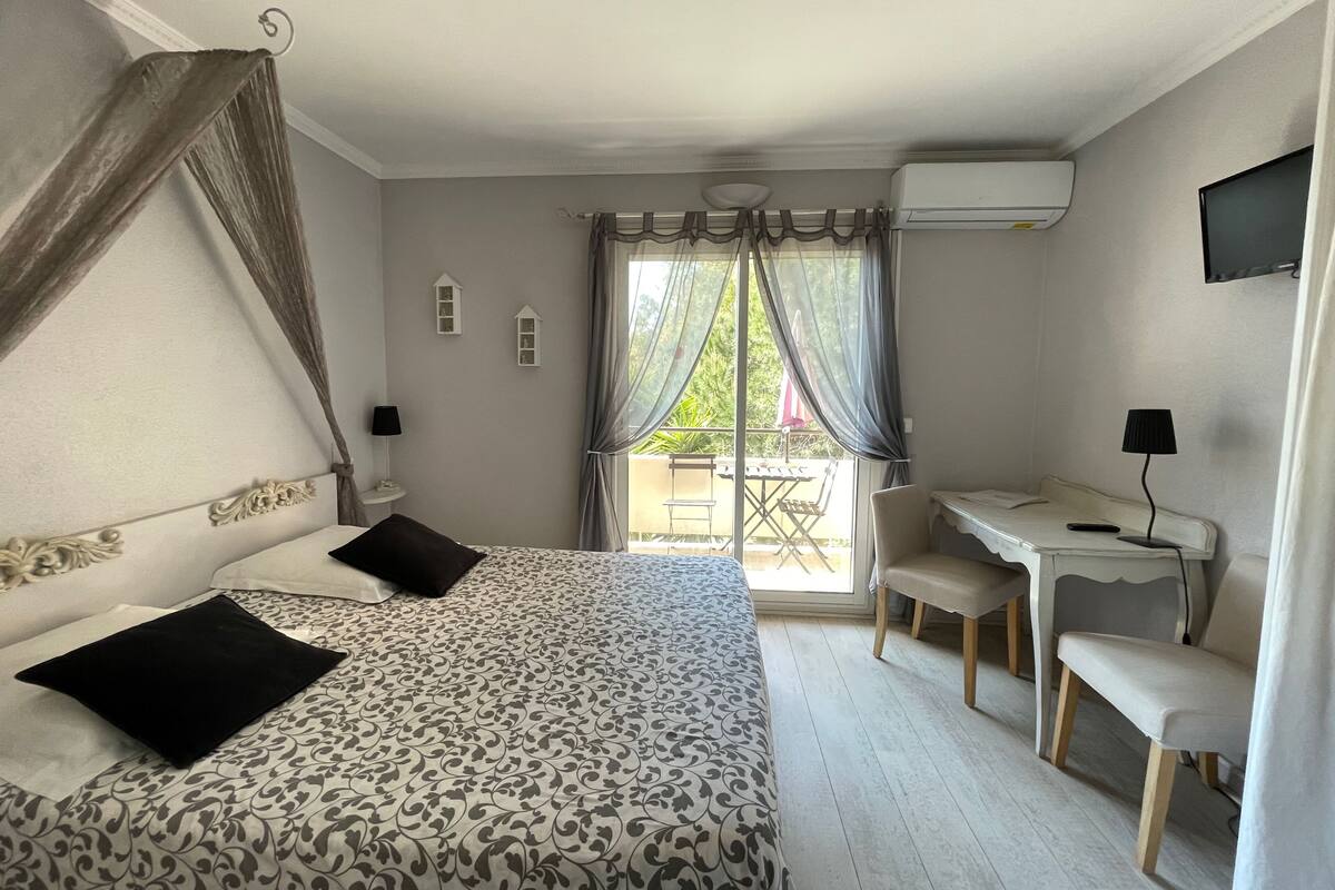 A bedroom with a bed, a desk, and a chair.