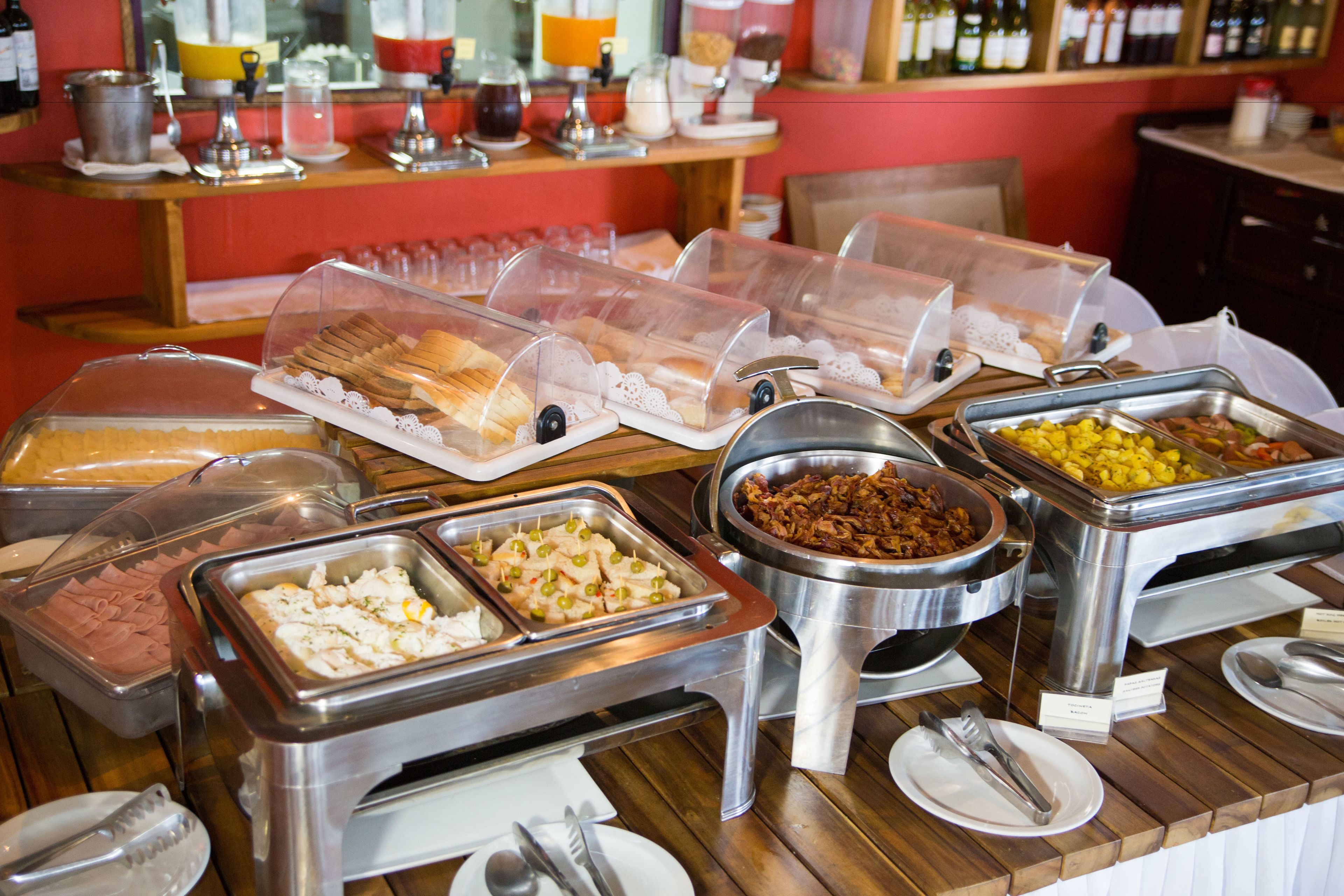 A buffet with various food items in clear containers, including meats, cheeses, and fruits.