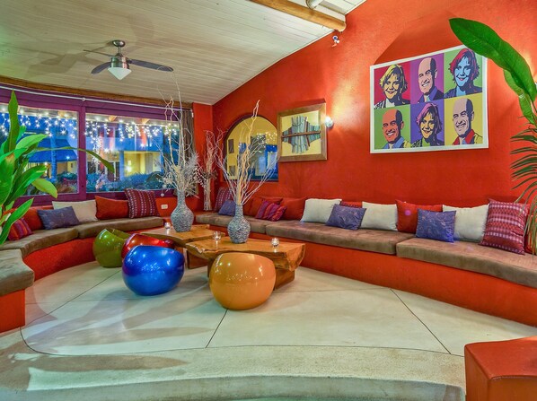 A vibrant living room with a curved sofa, colorful cushions, and decorative vases. - Hotel Alisei (Las Terrenas)