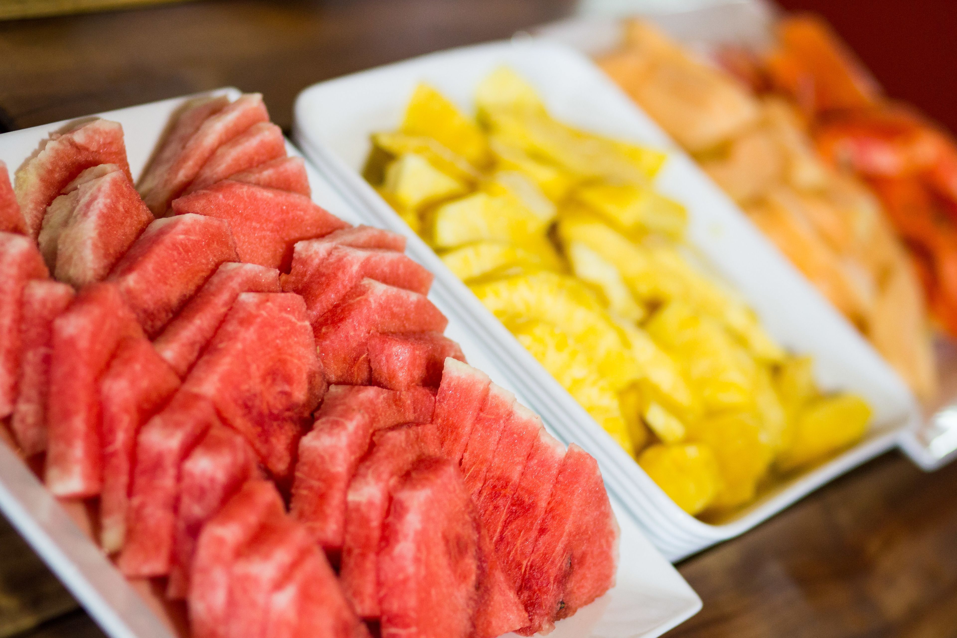 Una bandeja con sandía y piña en rodajas.