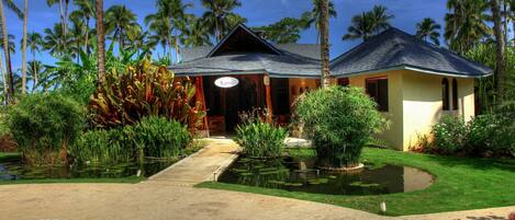 Un resort con piscina, palmeras y un jardín bien cuidado.