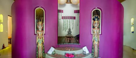 A temple with a central altar, two statues, and a staircase leading to the altar.