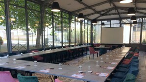 A conference room with a long table, chairs, and a projector screen.