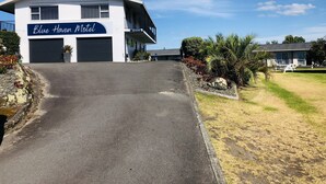A two-story Blue Haven Motel with a flat roof, large garage doors, and a covered parking area. - Blue Haven Motel (Tauranga)