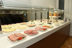 Ein Buffet mit verschiedenen Speisen und einer Getränkeausgabe.