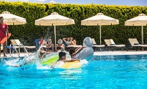 Una piscina al aire libre, sombrillas, sillones reclinables de piscina