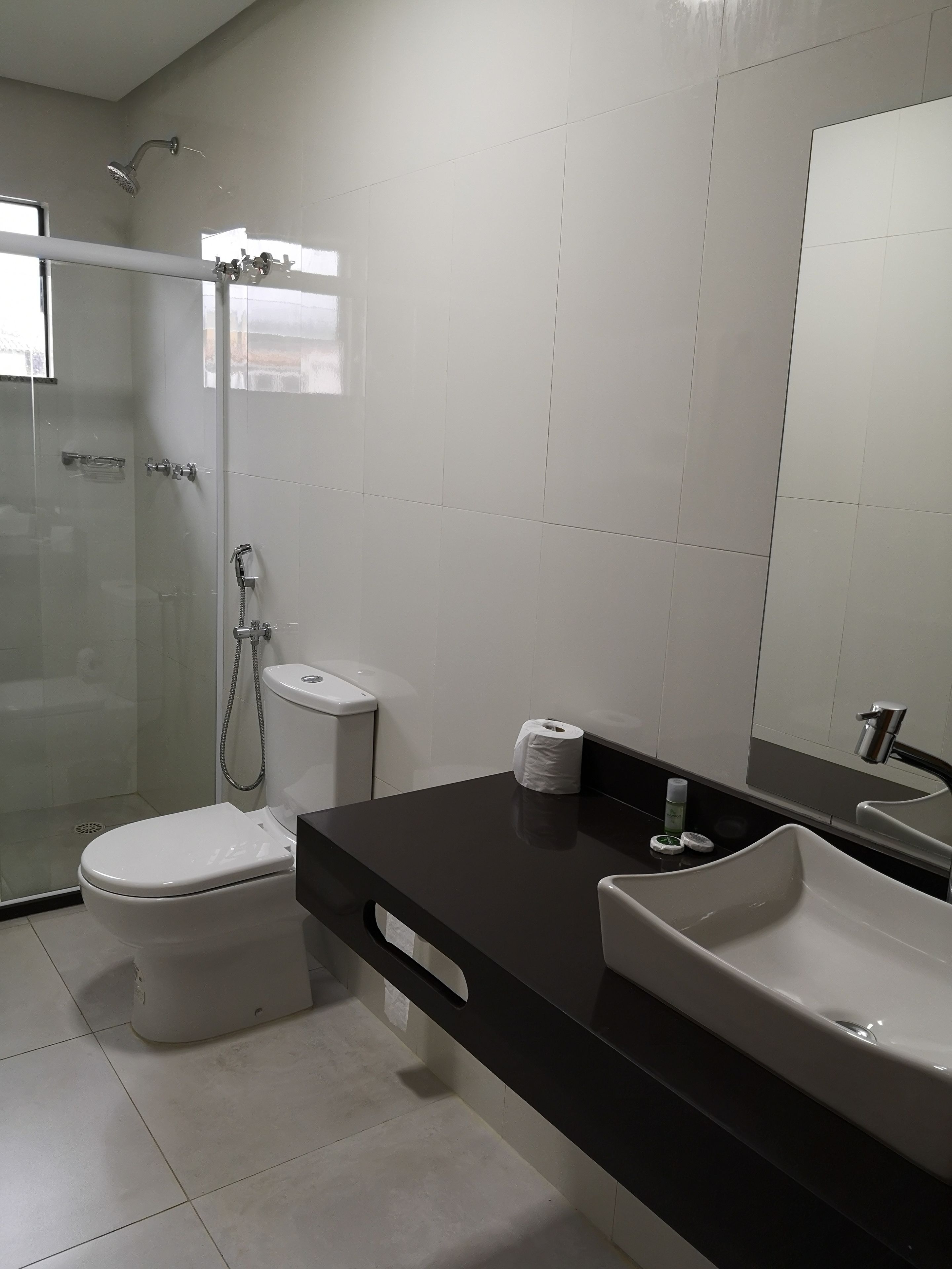 Un baño moderno con ducha de vidrio, inodoro y lavabo.