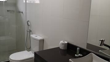 Un baño moderno con ducha de vidrio, inodoro y lavabo.