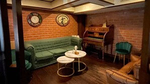 Une pièce chaleureuse avec un canapé vert, une petite table ronde et un meuble en bois.
