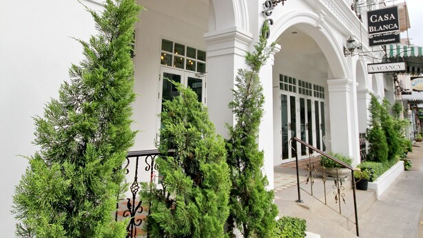 Un edificio blanco con un letrero que dice 'Casa Blanca' y 'Habitaciones disponibles'.