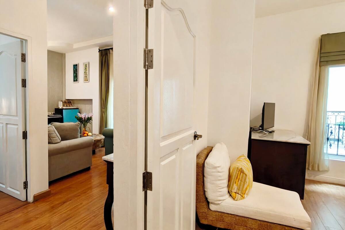 Una habitación de hotel con una cama, un sofá, una mesita y un televisor.
