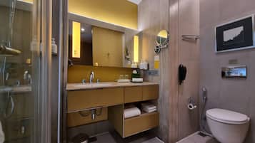 A modern bathroom with a glass shower enclosure, a wooden vanity with a sink, a mirror, and a toilet.